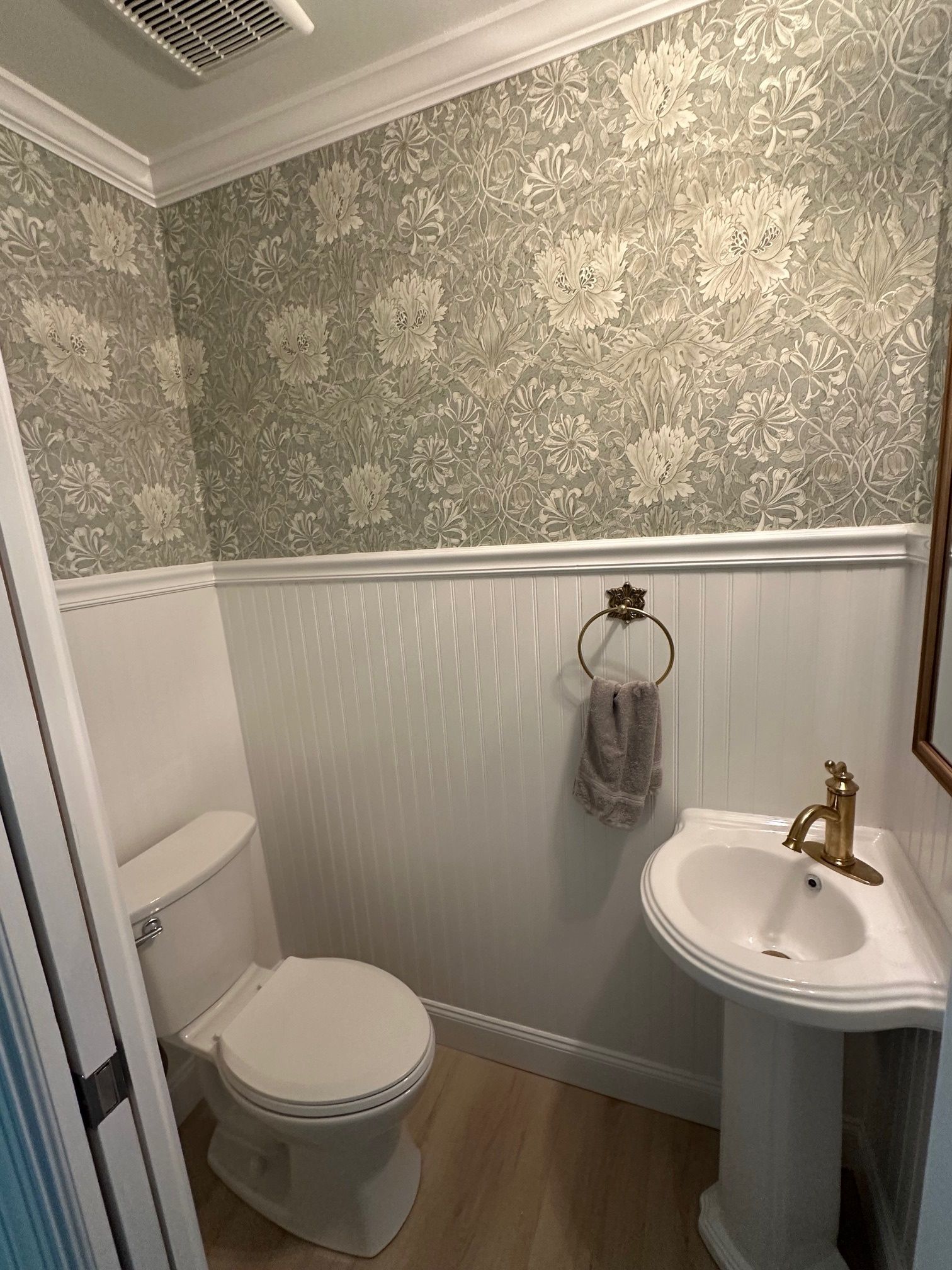 A bathroom with a toilet, sink, and mirror