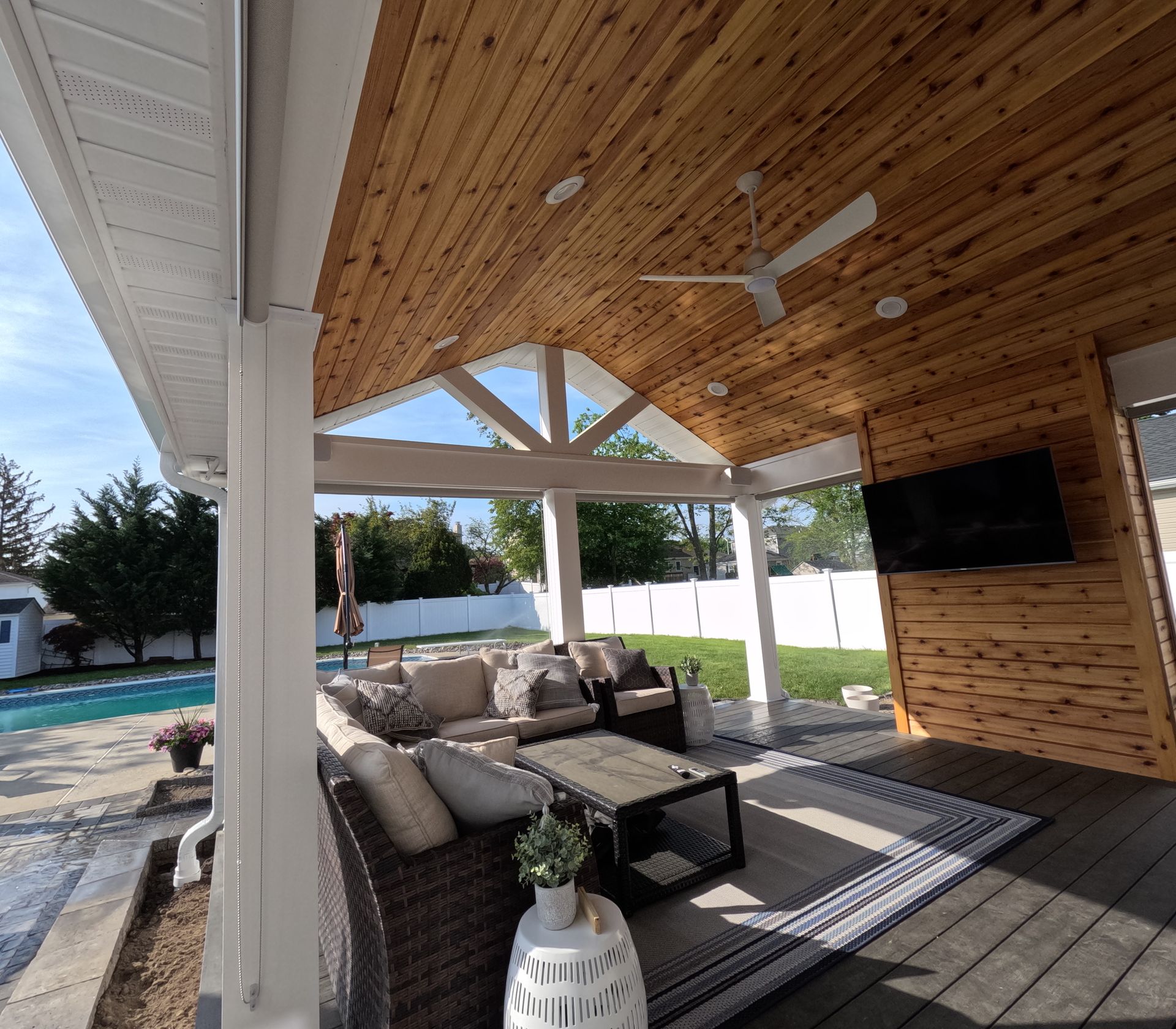 A patio with a ceiling fan and a television