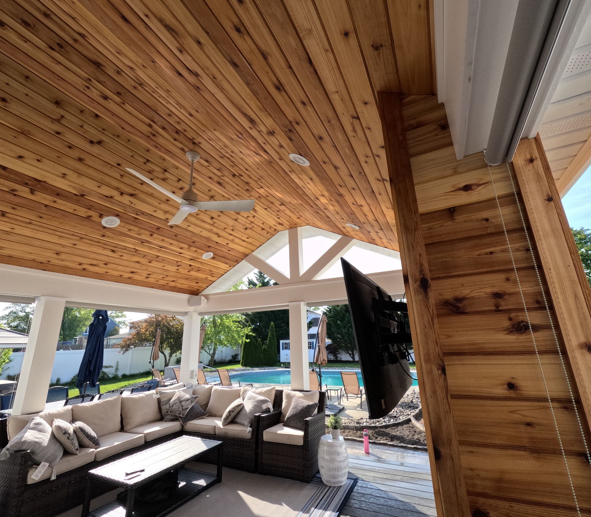 A living room with a ceiling fan and a flat-screen TV