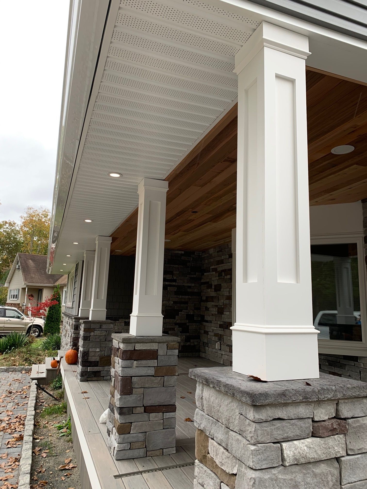 A porch with white columns and brick pillars
