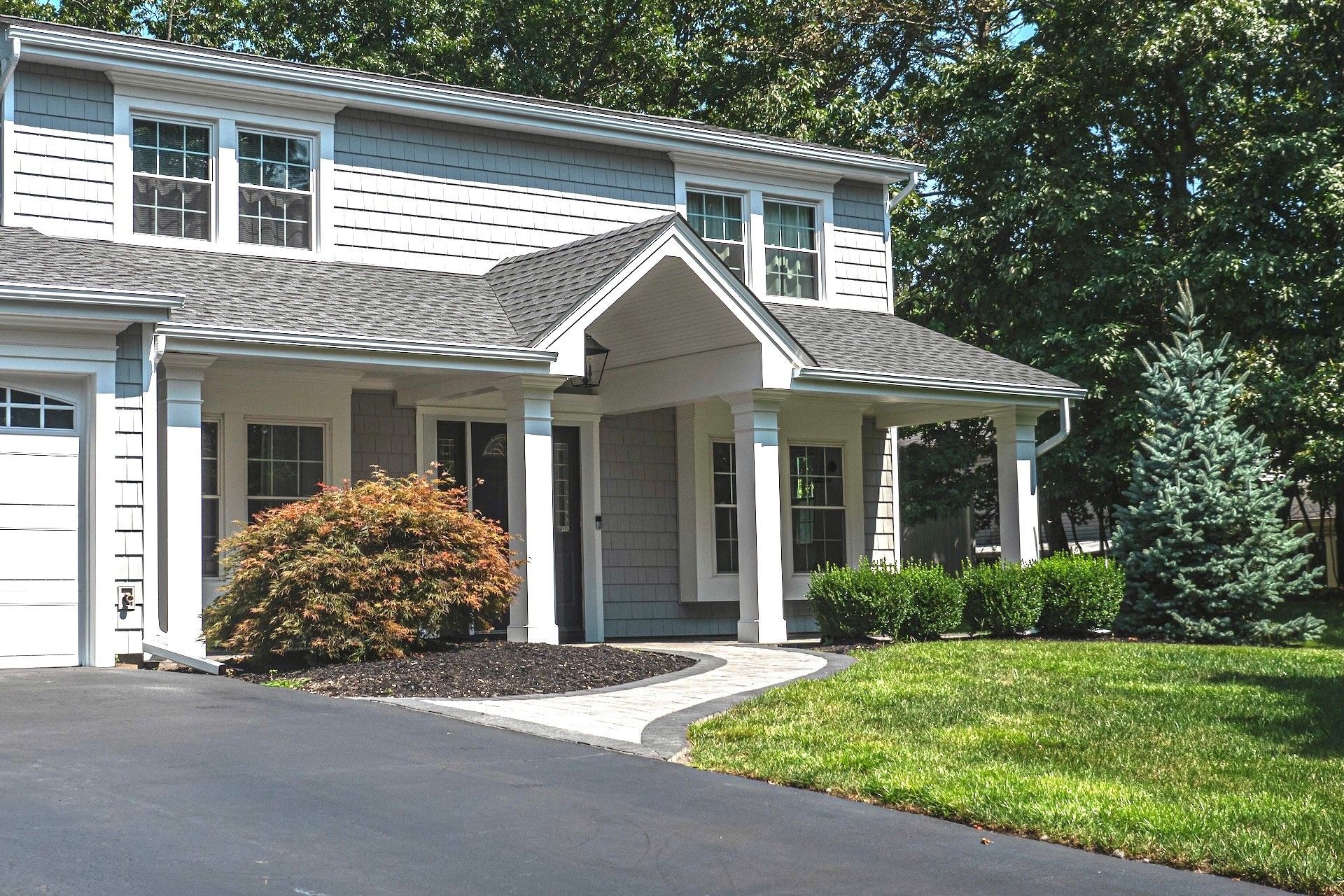 A white house with a porch and a driveway