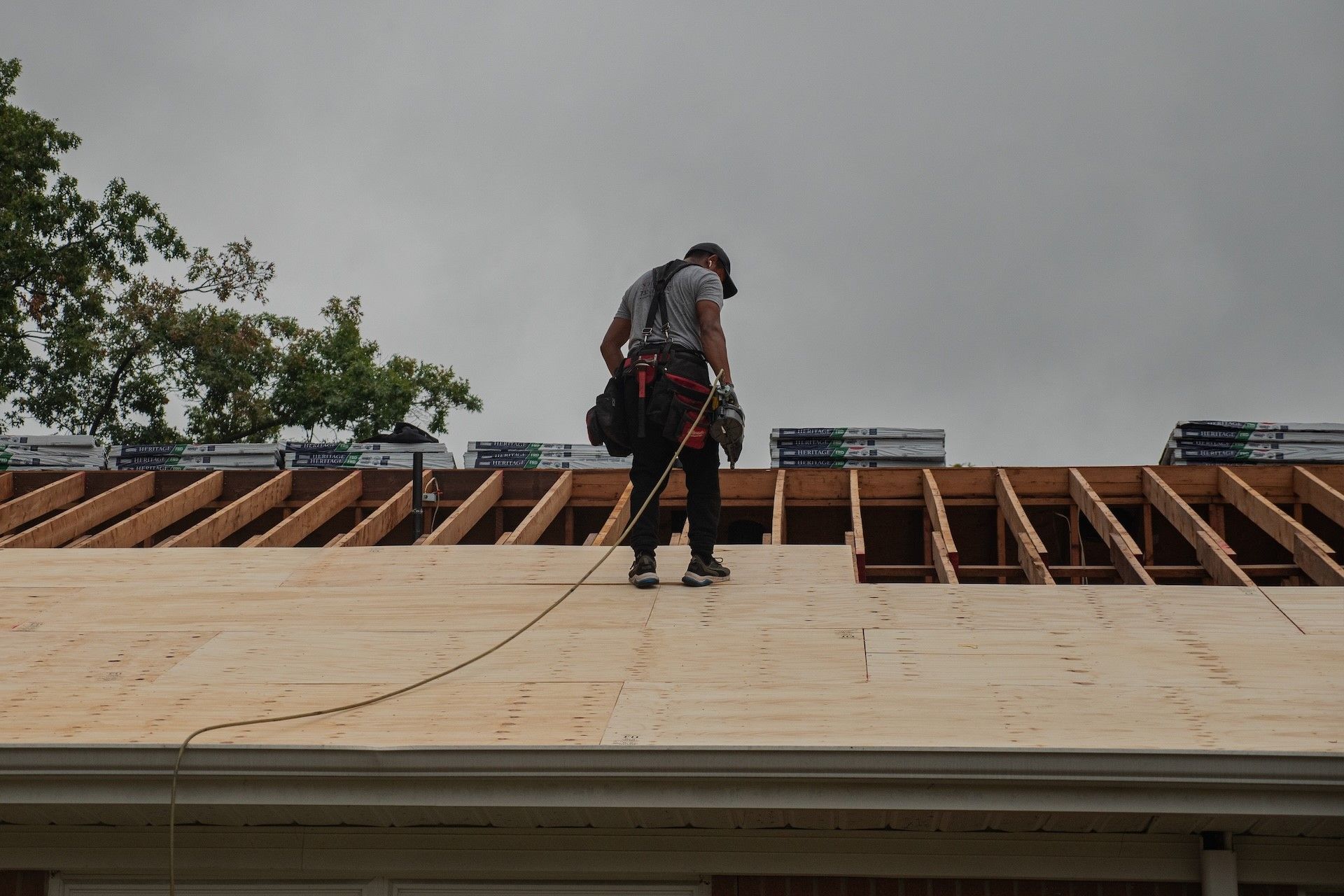 A man is working on the roof of a house.