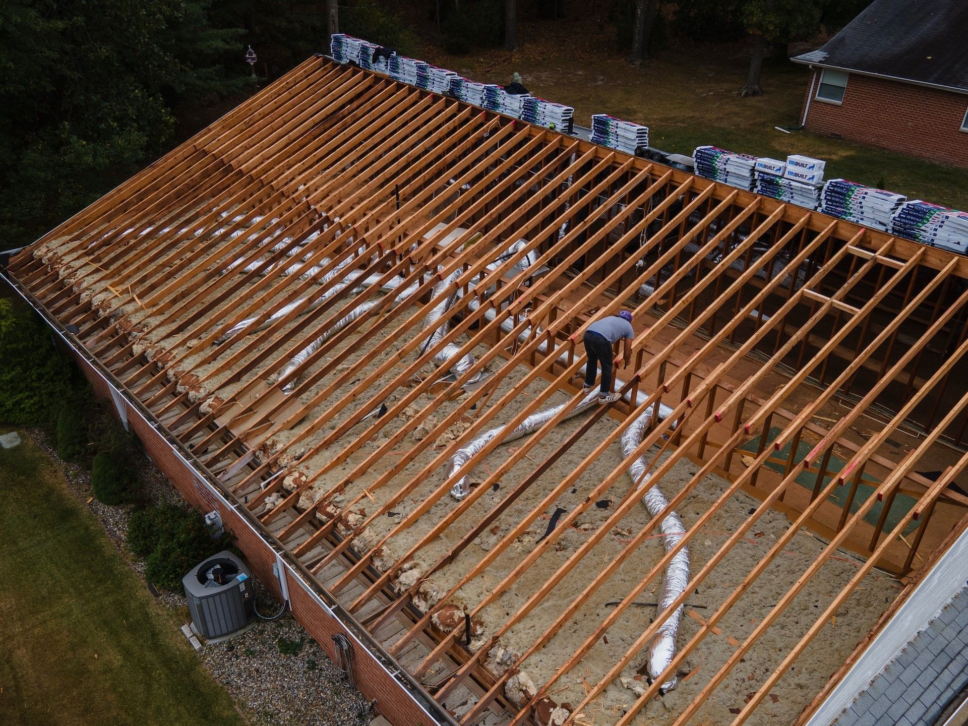 A man is working on the roof of a house.