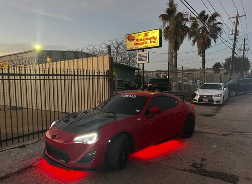 red car outside JC Autobody Repair shop