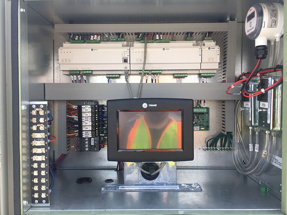 Industrial control panel with a display showing a green and orange graphic.