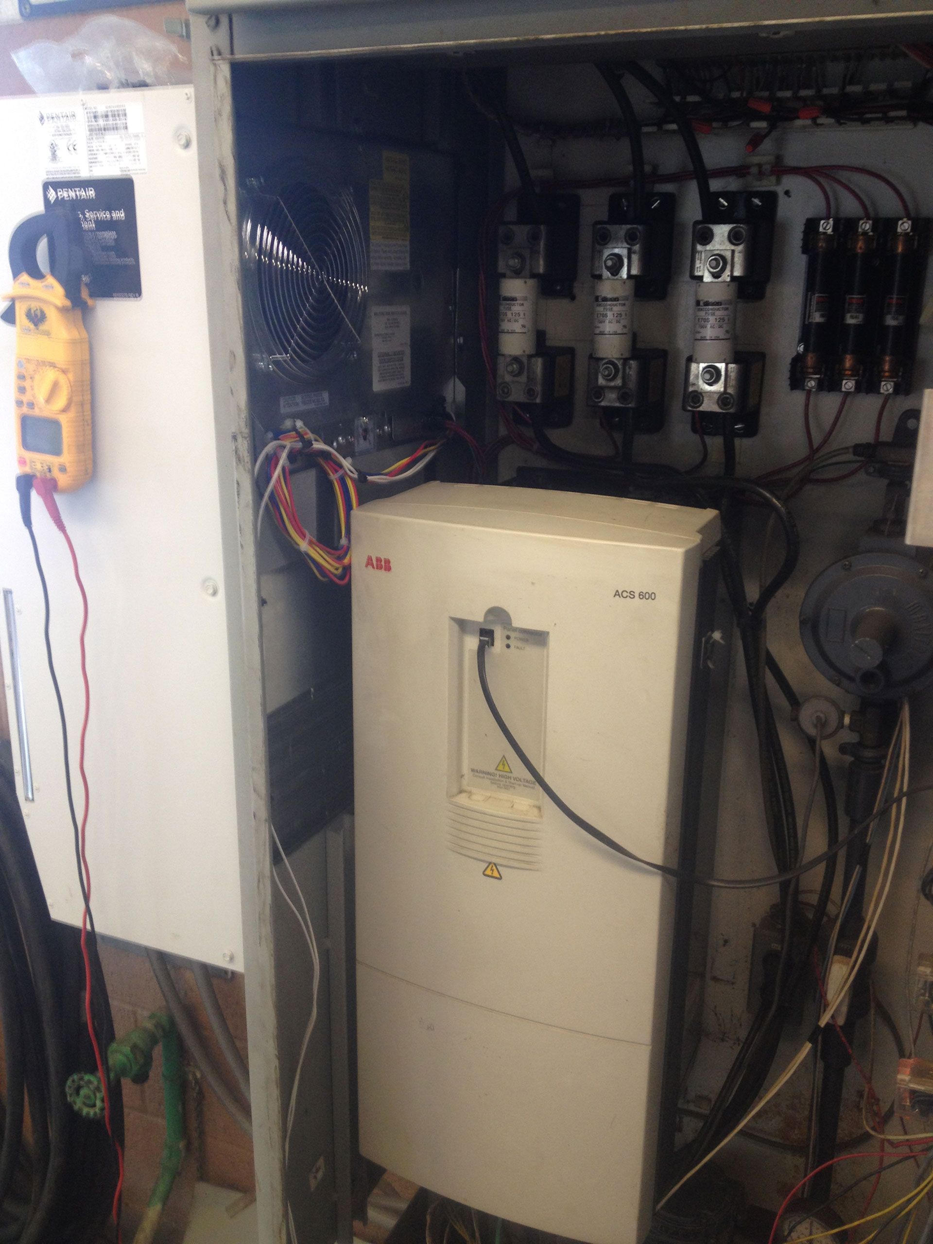 Electrical panel with a multimeter, various components, and wiring inside.