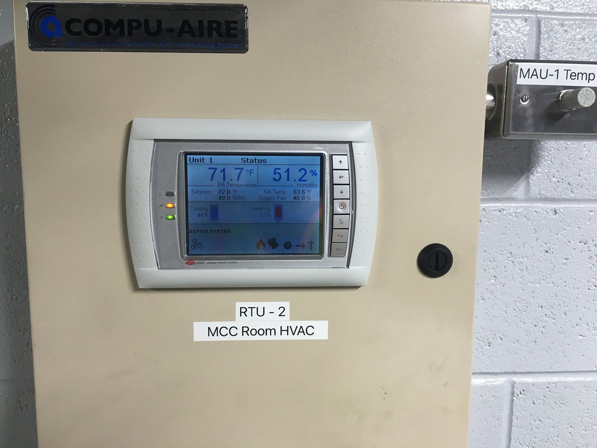 Control panel for HVAC system, with screen displaying temperatures and settings.