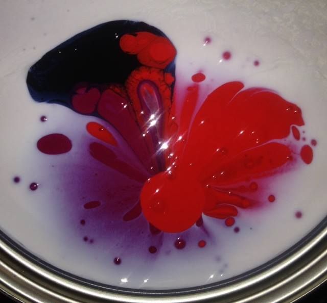 A close up of a can of red and purple paint