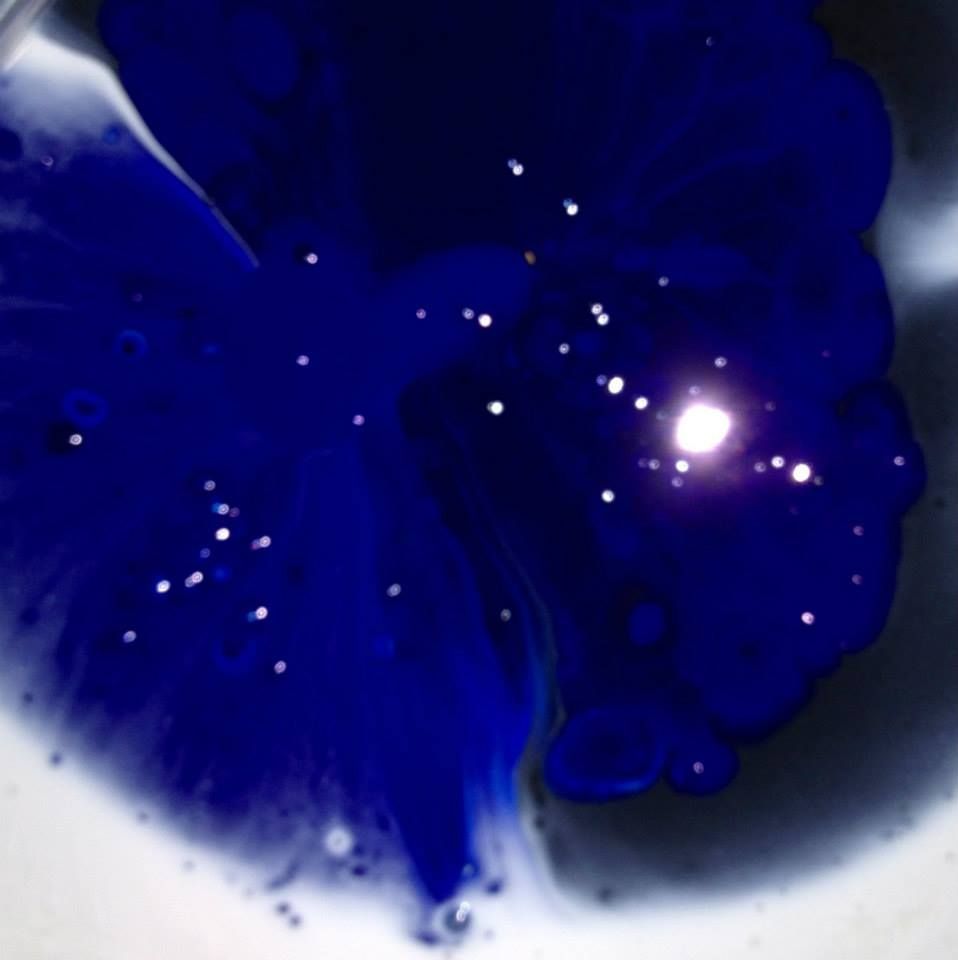 A close up of a blue liquid with a light in the middle