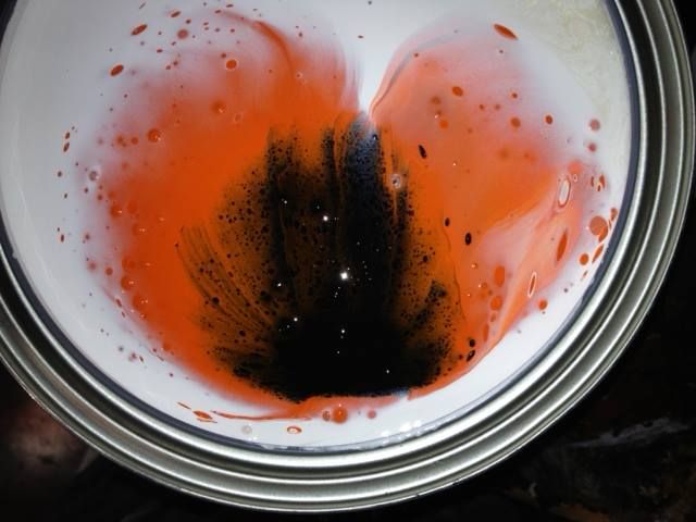 A close up of a can of orange and black paint