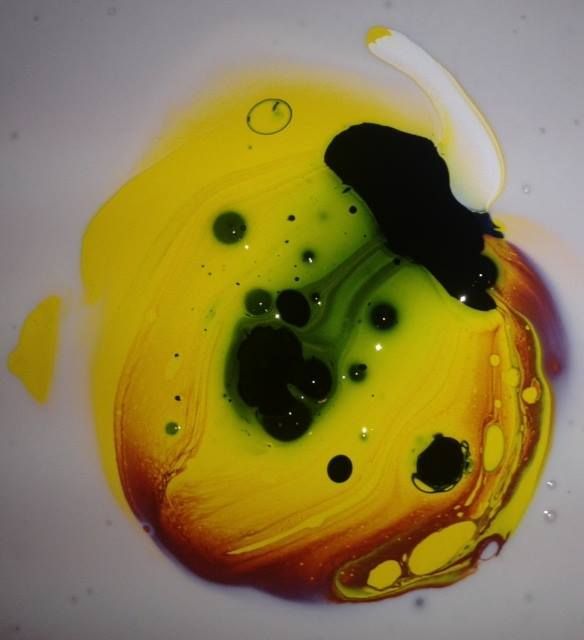A close up of a yellow and purple paint swirl