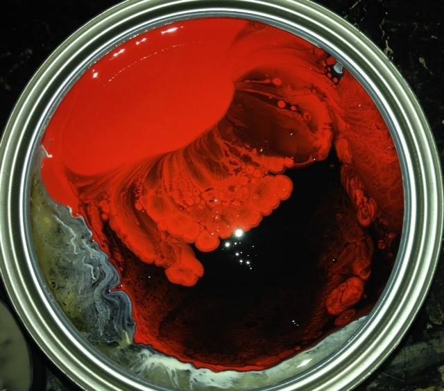 A can of red paint is sitting on a table