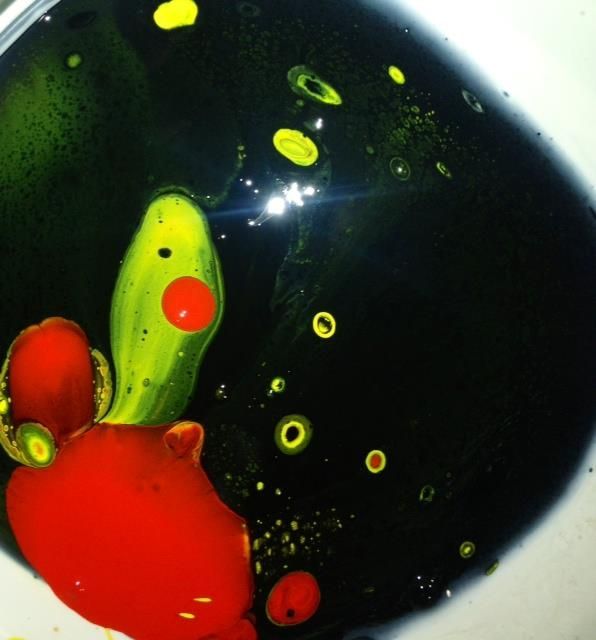 A close up of a bowl of liquid with a red and green object in it