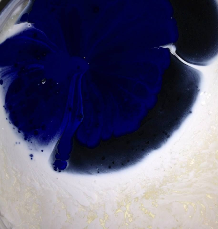 A close up of a blue and white liquid in a bowl.