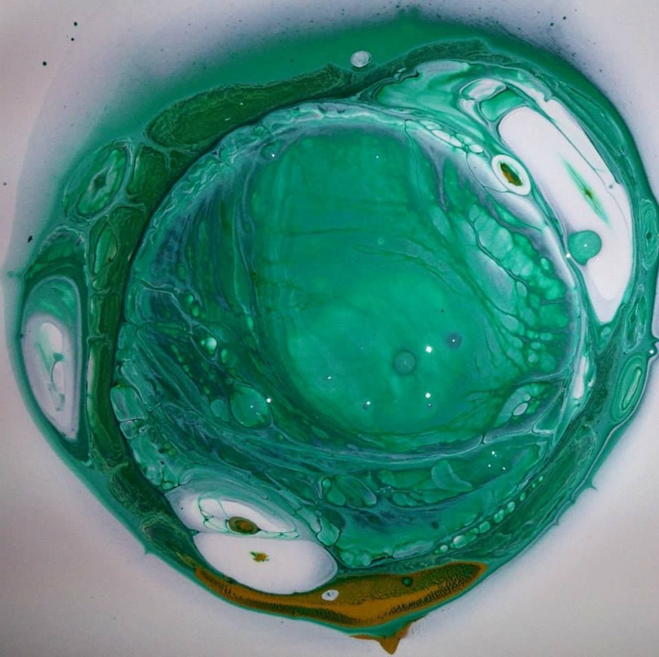 A close up of a green and white painting on a white surface