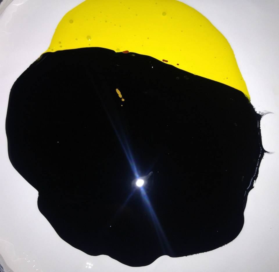 A white plate with yellow and black paint on it