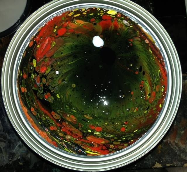 A can of paint has a green and red swirl in it