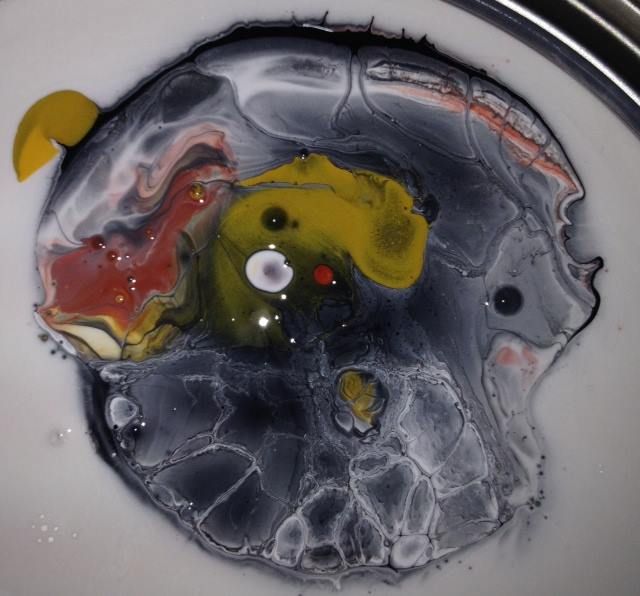 A close up of a painting with a yellow circle in the middle