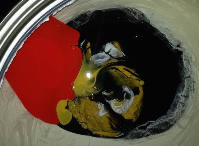 A close up of a can of paint with red yellow and black paint