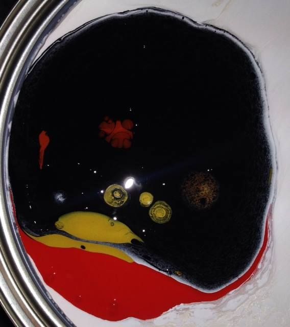 A close up of a can of red and black paint