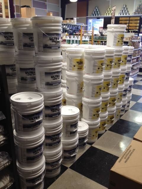 Buckets of paint are stacked on top of each other in a store