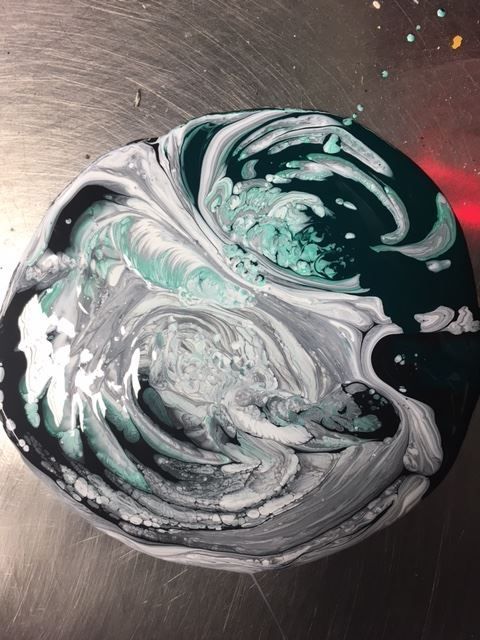 A black and white marbled circle on a metal surface