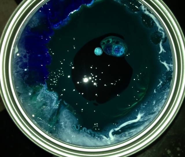 A can of blue liquid with bubbles in it