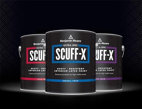 Three cans of benjamin moore scuff-x paint are sitting on a table.