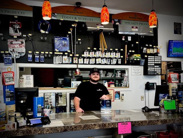 A man stands behind a counter in a store with a sign that says ' a ' on it