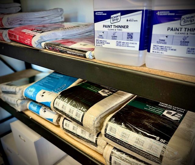A shelf full of paint thinners and paint cleaners
