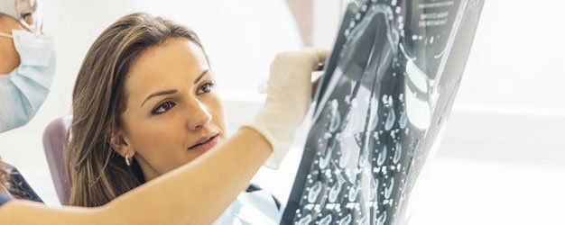 Woman examining an X-ray film in a medical setting