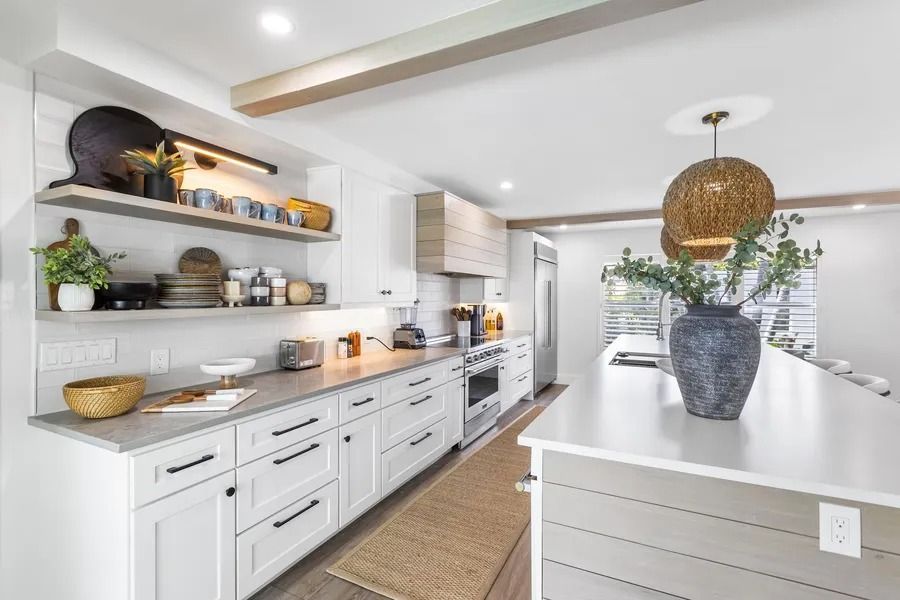 Modern kitchen with white cabinets, open shelving, and a large island.