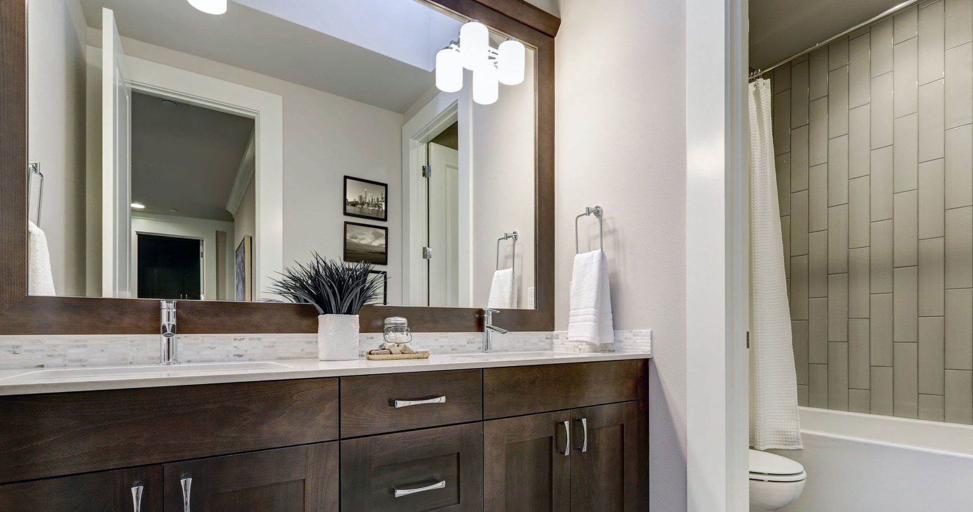 A bathroom with two sinks , a toilet , and a large mirror.