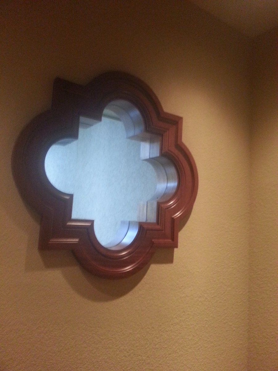 A mirror with a wooden frame is hanging on a wall