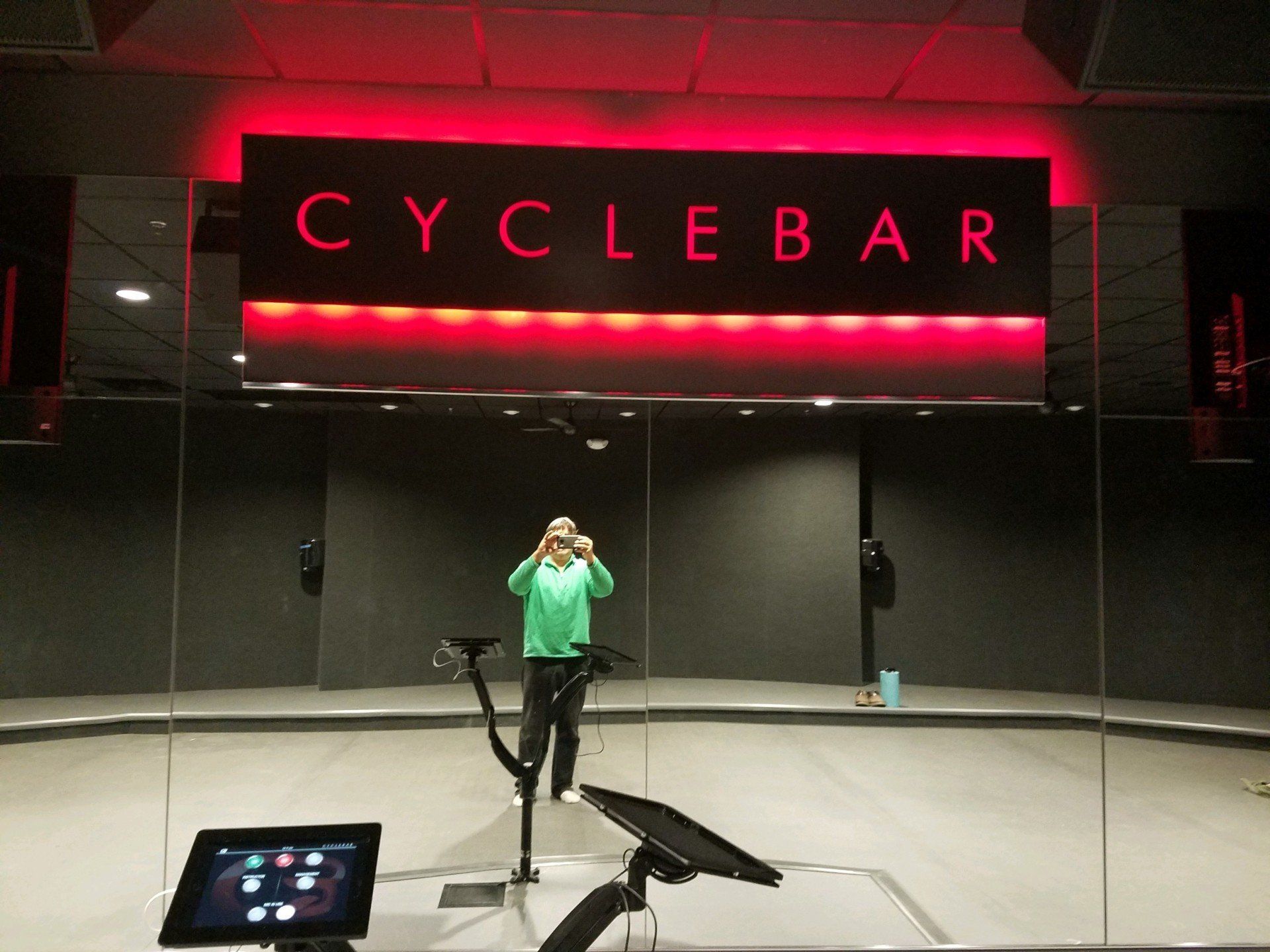 A woman is standing in front of a cycle bar sign