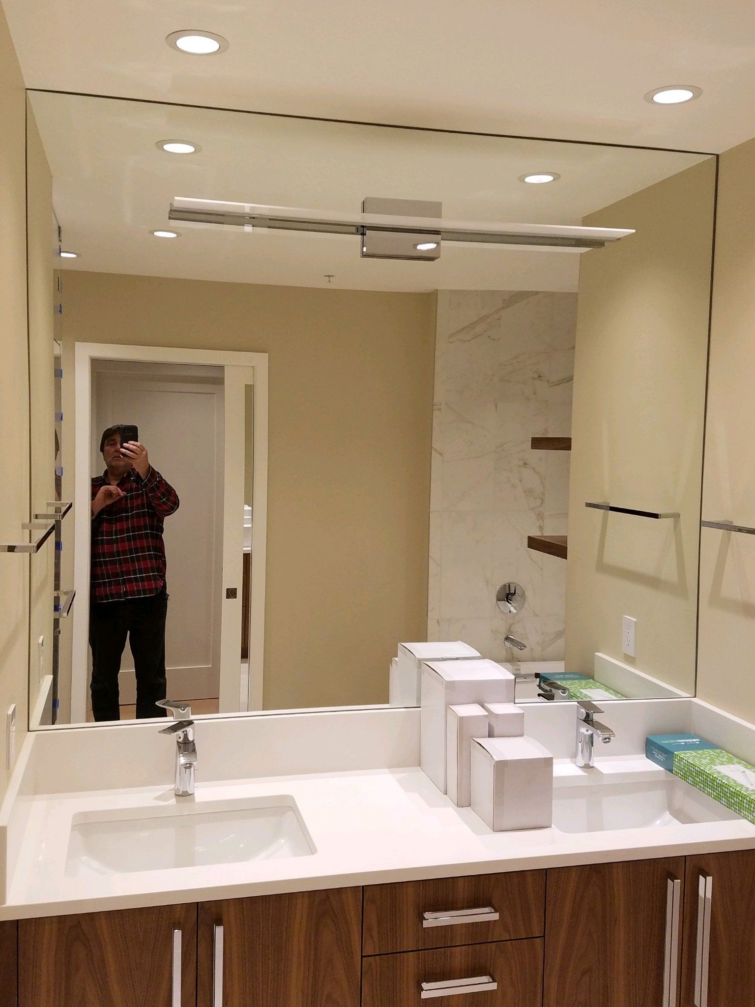 A man is taking a picture of himself in a bathroom mirror