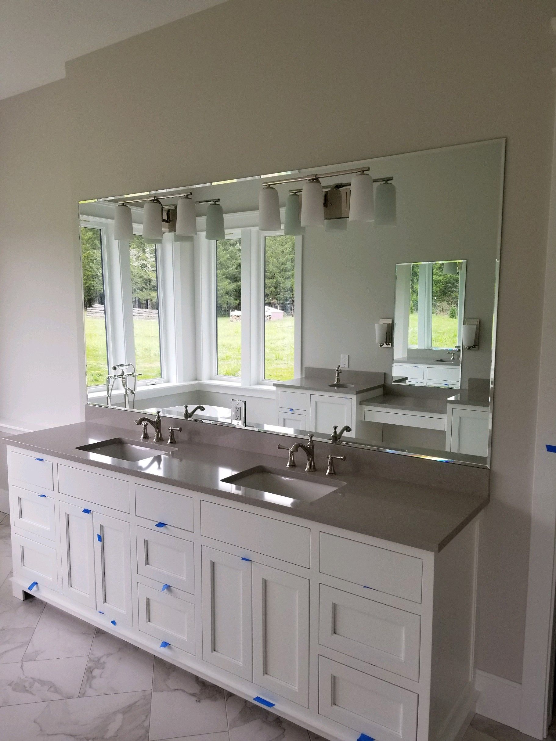 A bathroom with two sinks and a large mirror