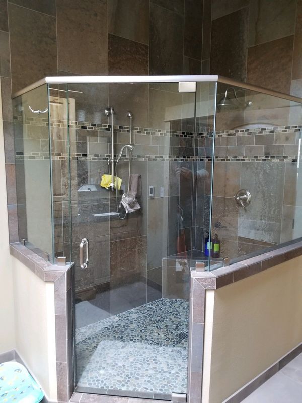 A bathroom with a glass shower door and a sink.