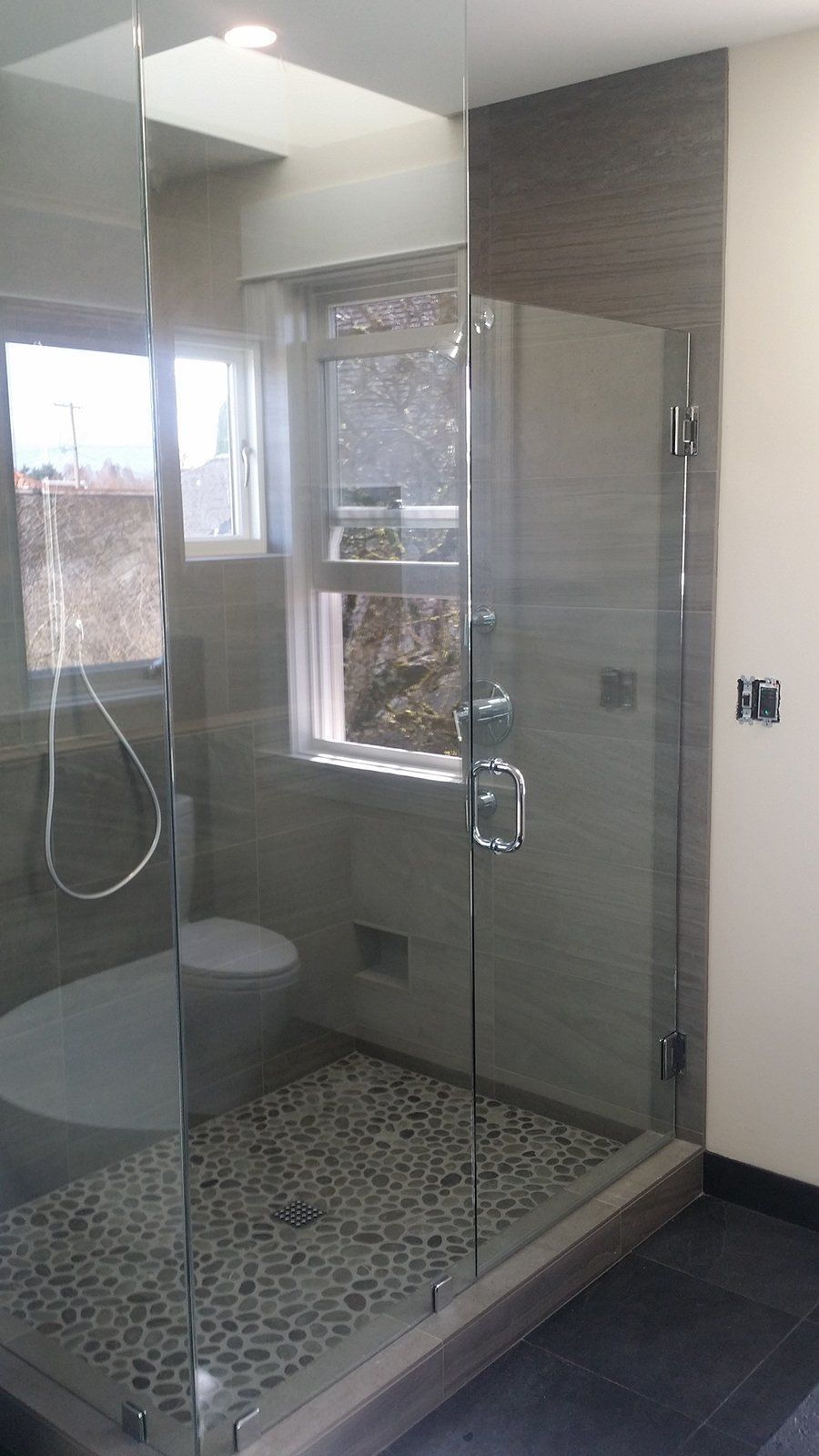 A bathroom with a toilet and a shower stall with a glass door.