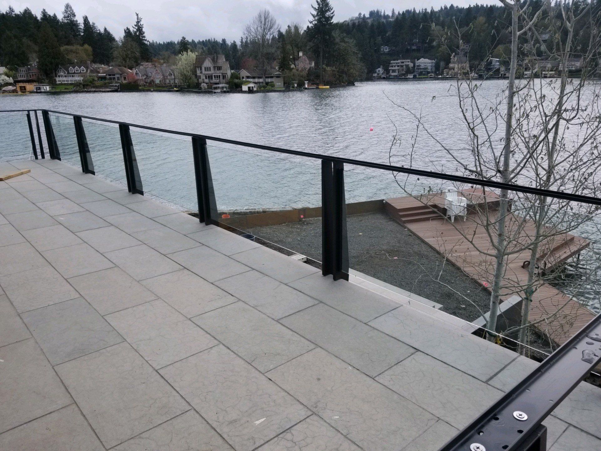 A balcony overlooking a lake with a glass railing