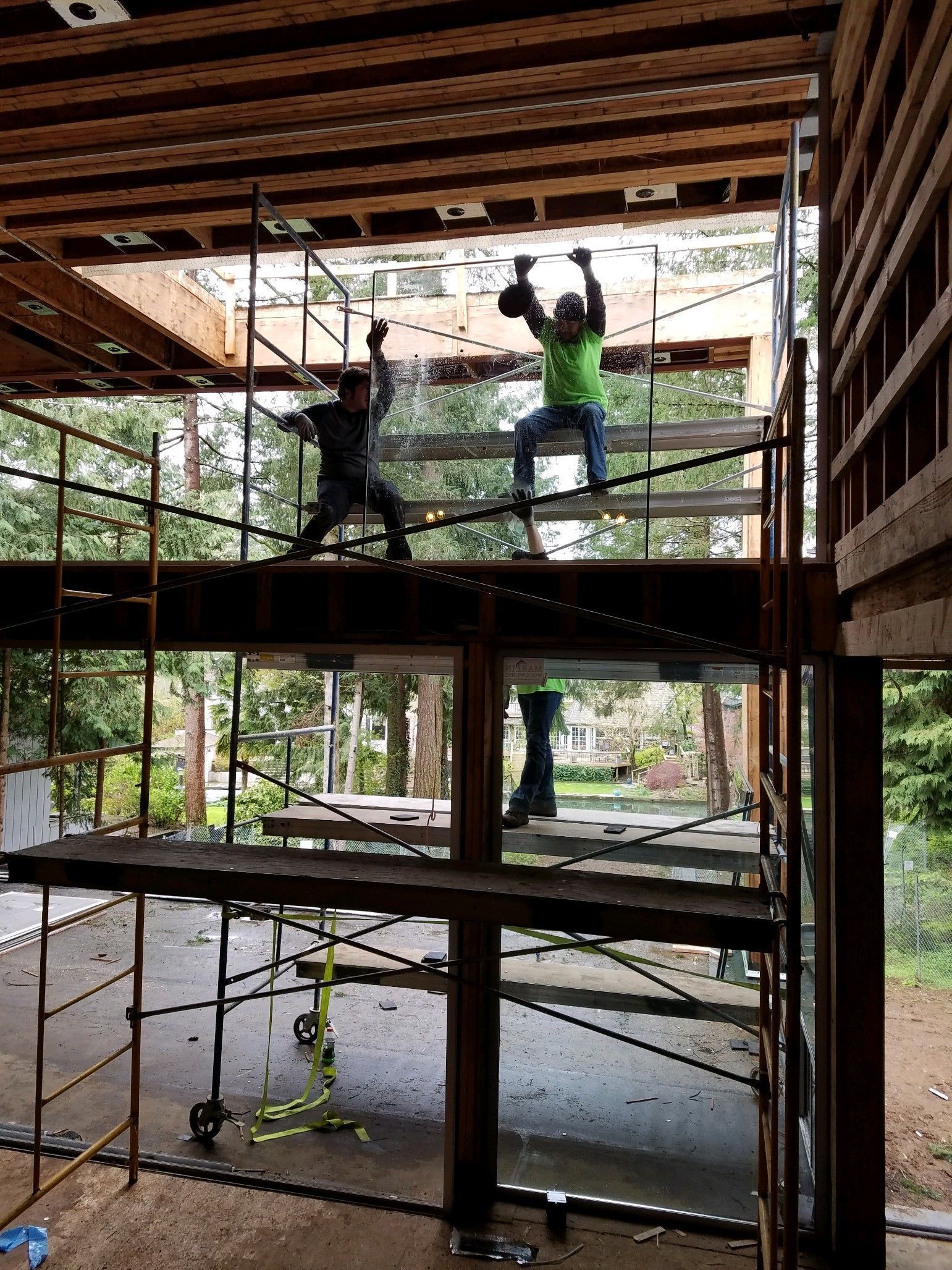 Two men are standing on scaffolding in a building under construction.