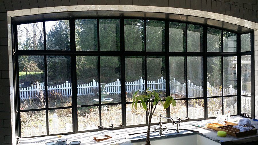 A kitchen with a large window and a sink.