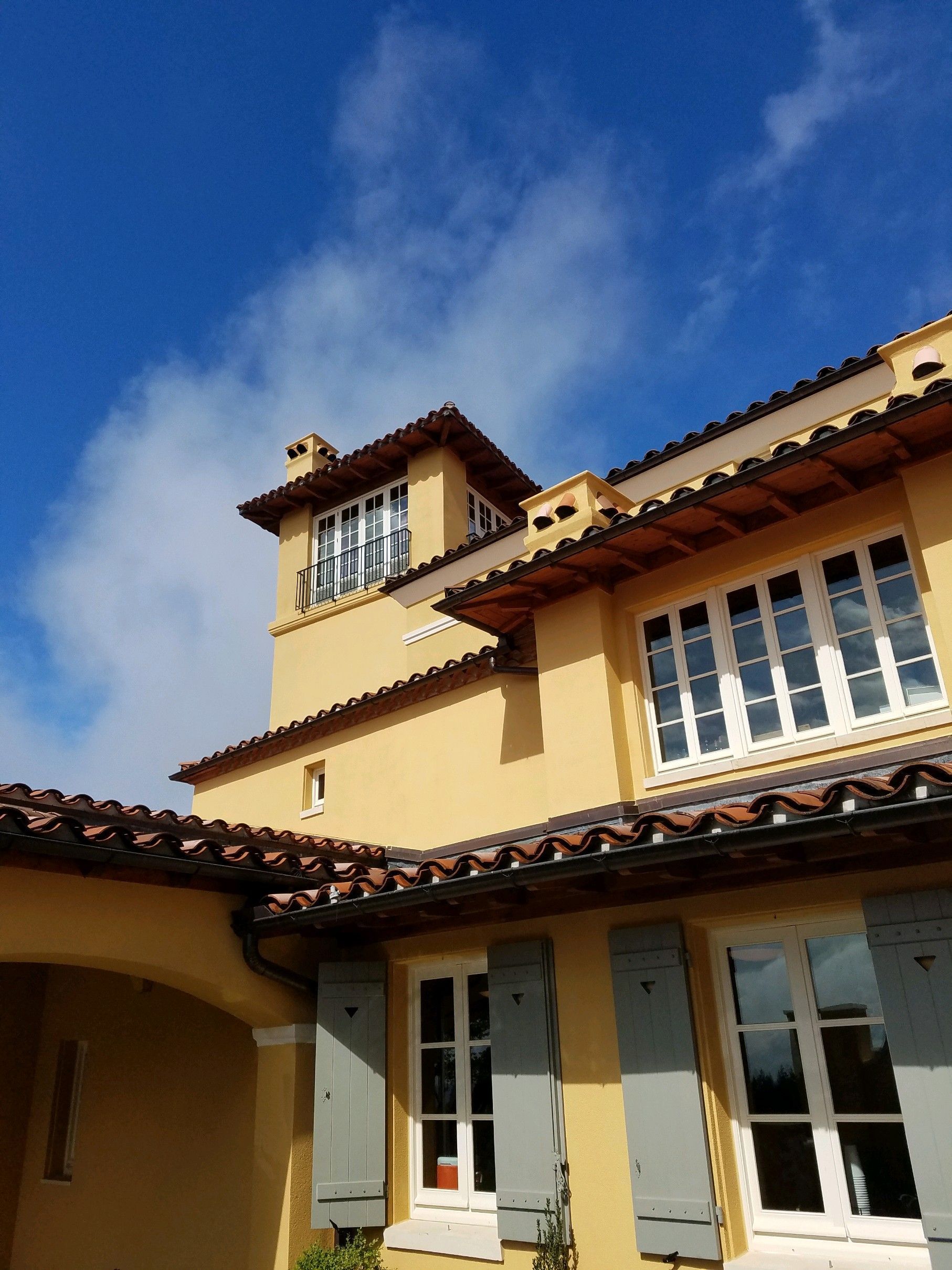 A yellow house with a blue sky in the background