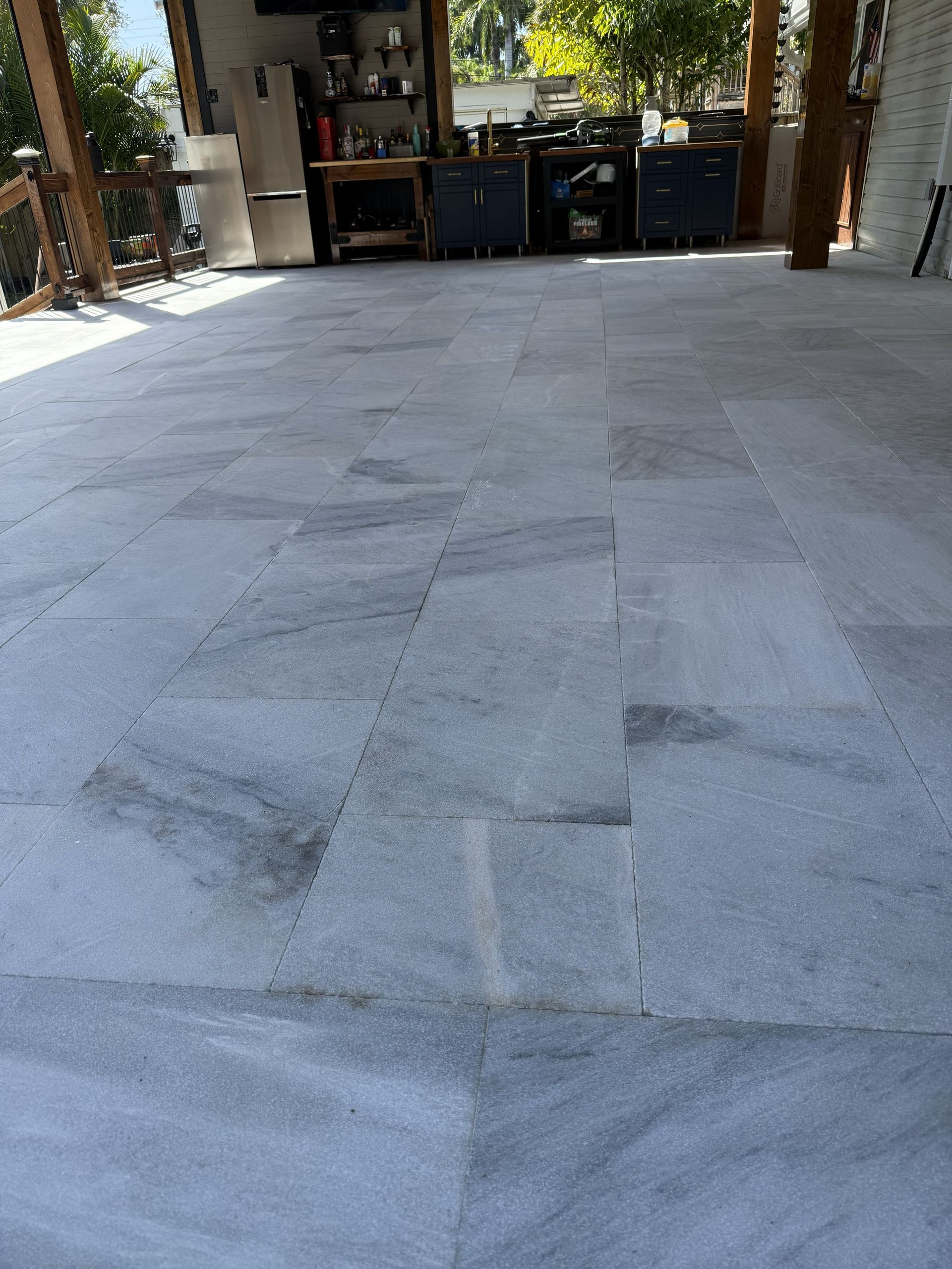 Stone patio leading to a garage with tools and storage shelves in the background