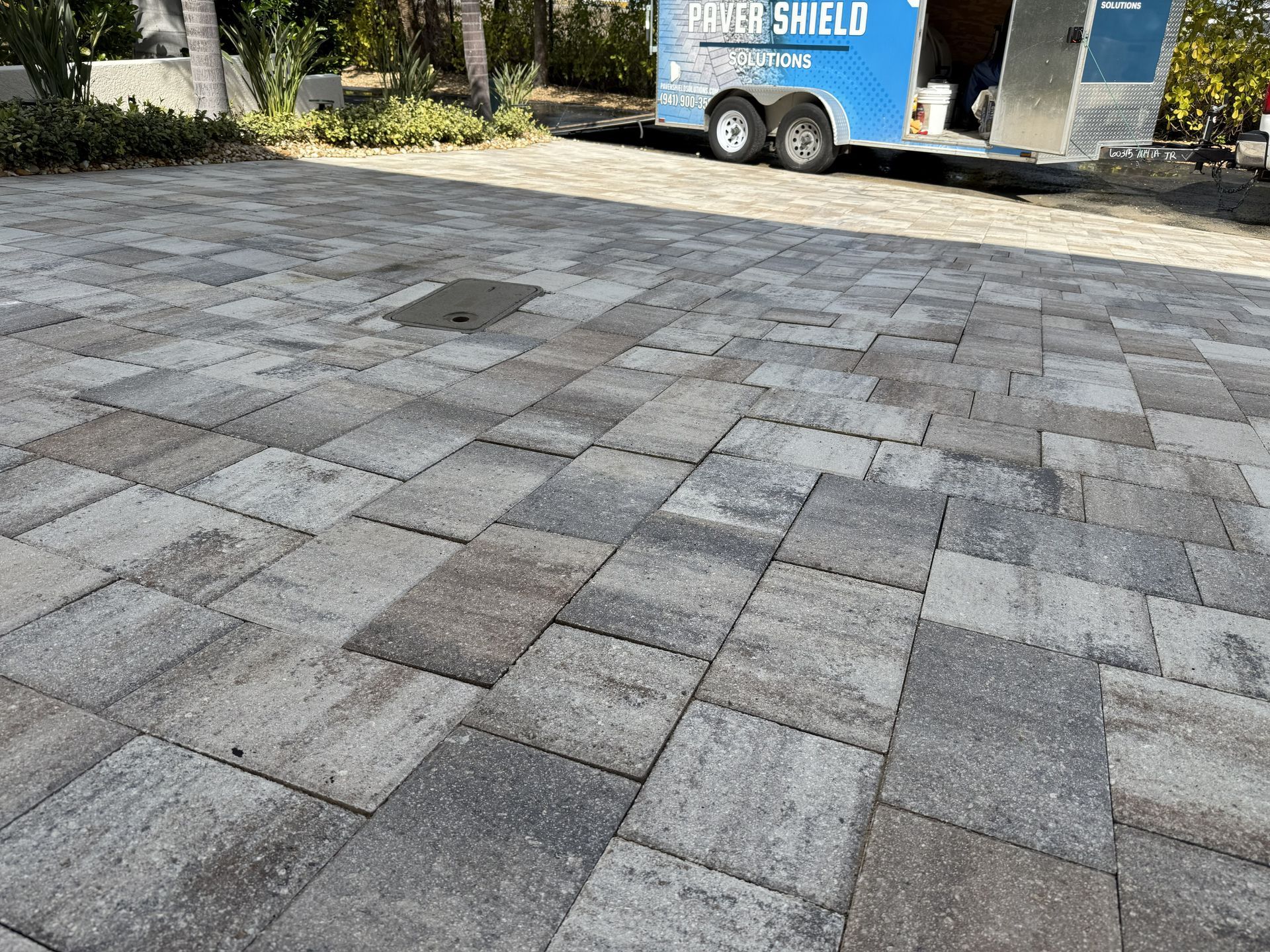 Stone-paved driveway with a blue trailer parked in the background