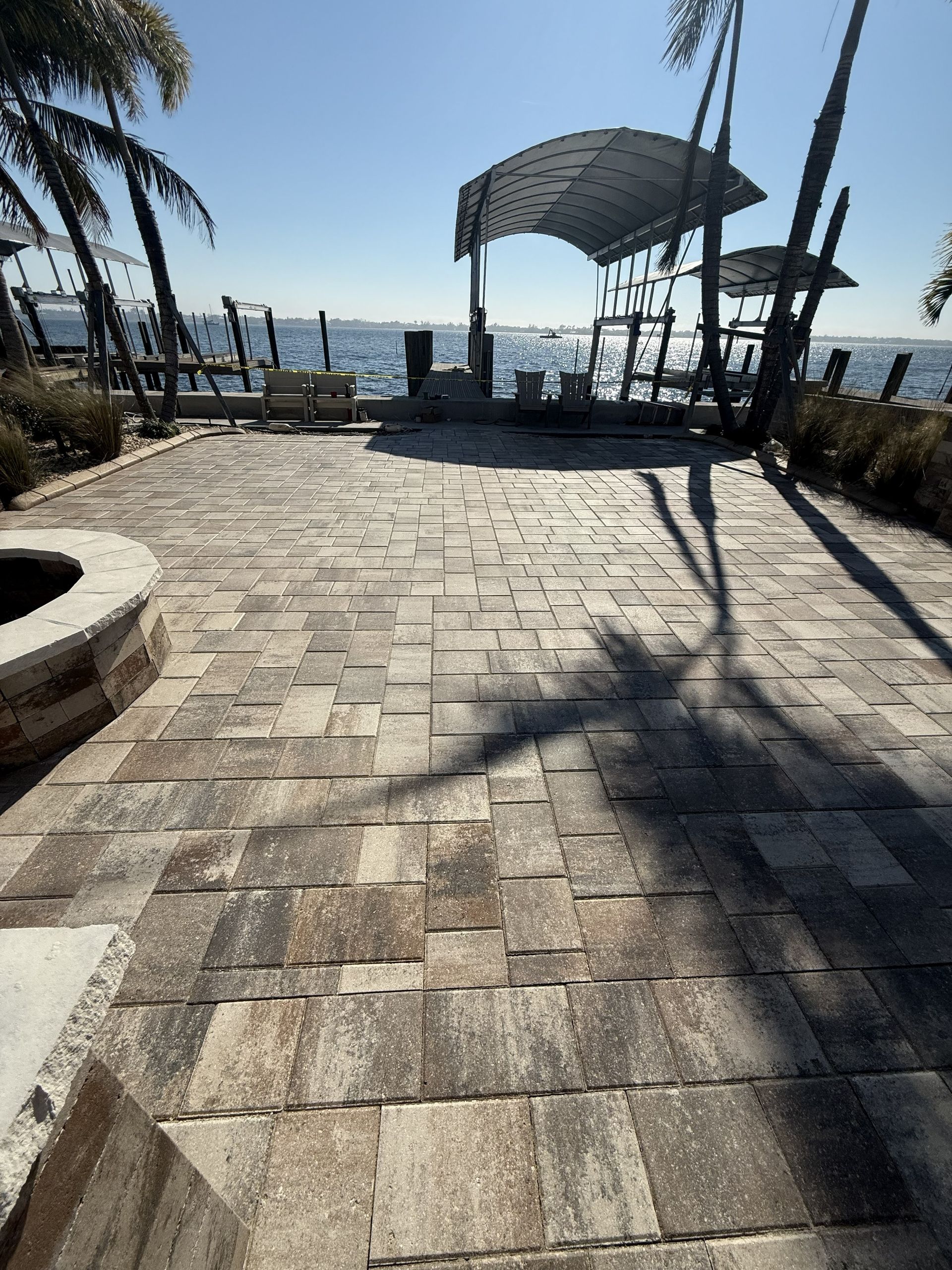 Stone walkway leading to a seaside pavilion with palm trees and ocean view