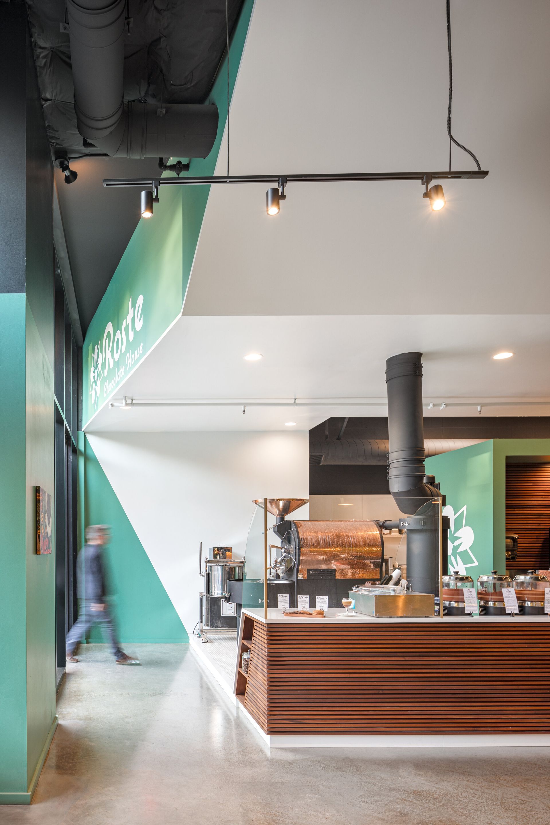 A restaurant with a wooden counter and a green wall.