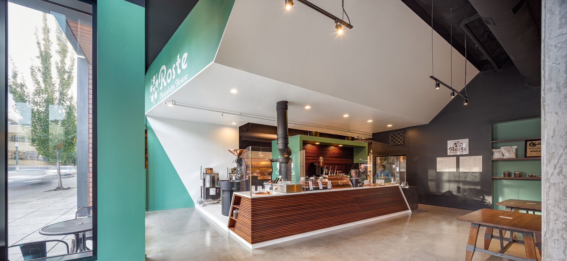 A restaurant with a green wall and a wooden counter.