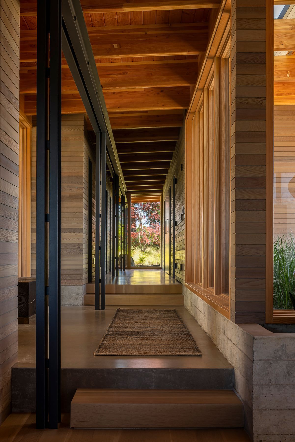 A long hallway in a house with a rug on the floor.