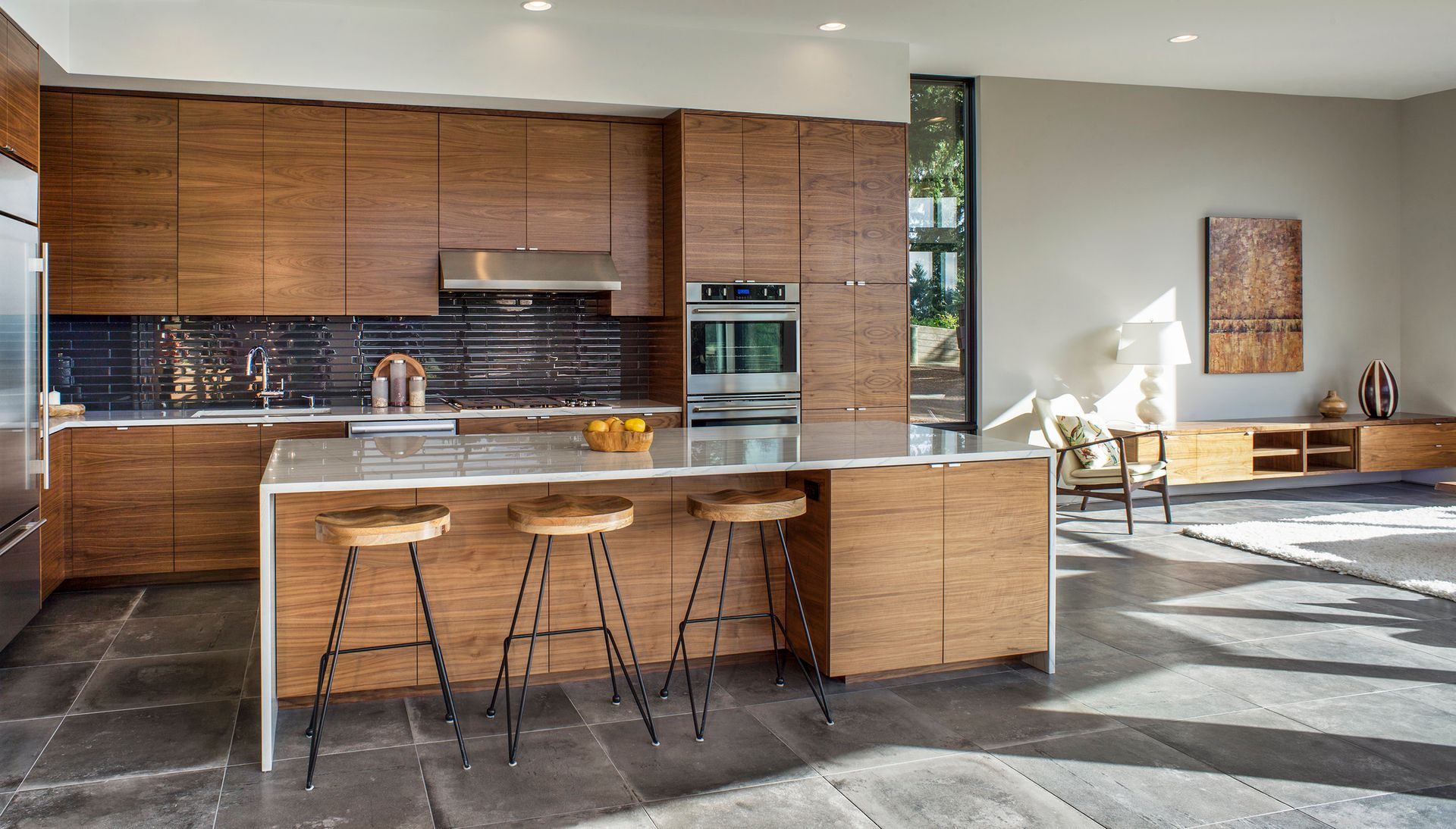 A kitchen with wooden cabinets and stools and a large island